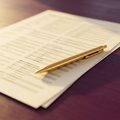 A printed state table page with a pen resting on it
